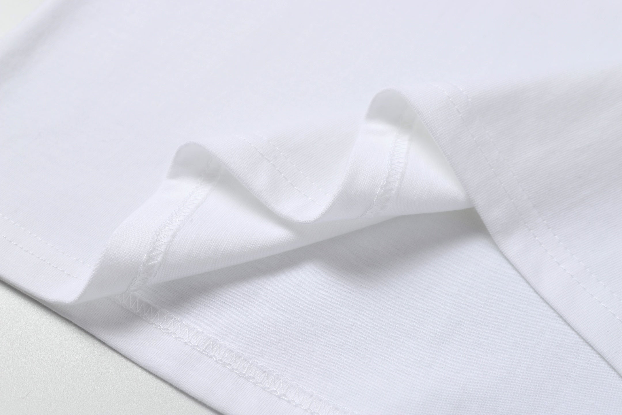 White Stone Island T-shirt hem with double-stitched seam detail.