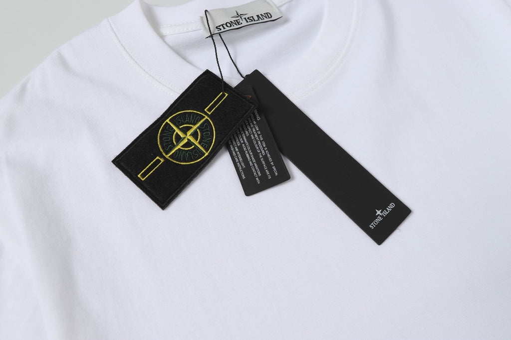 White Stone Island T-shirt with attached garment tags near collar.