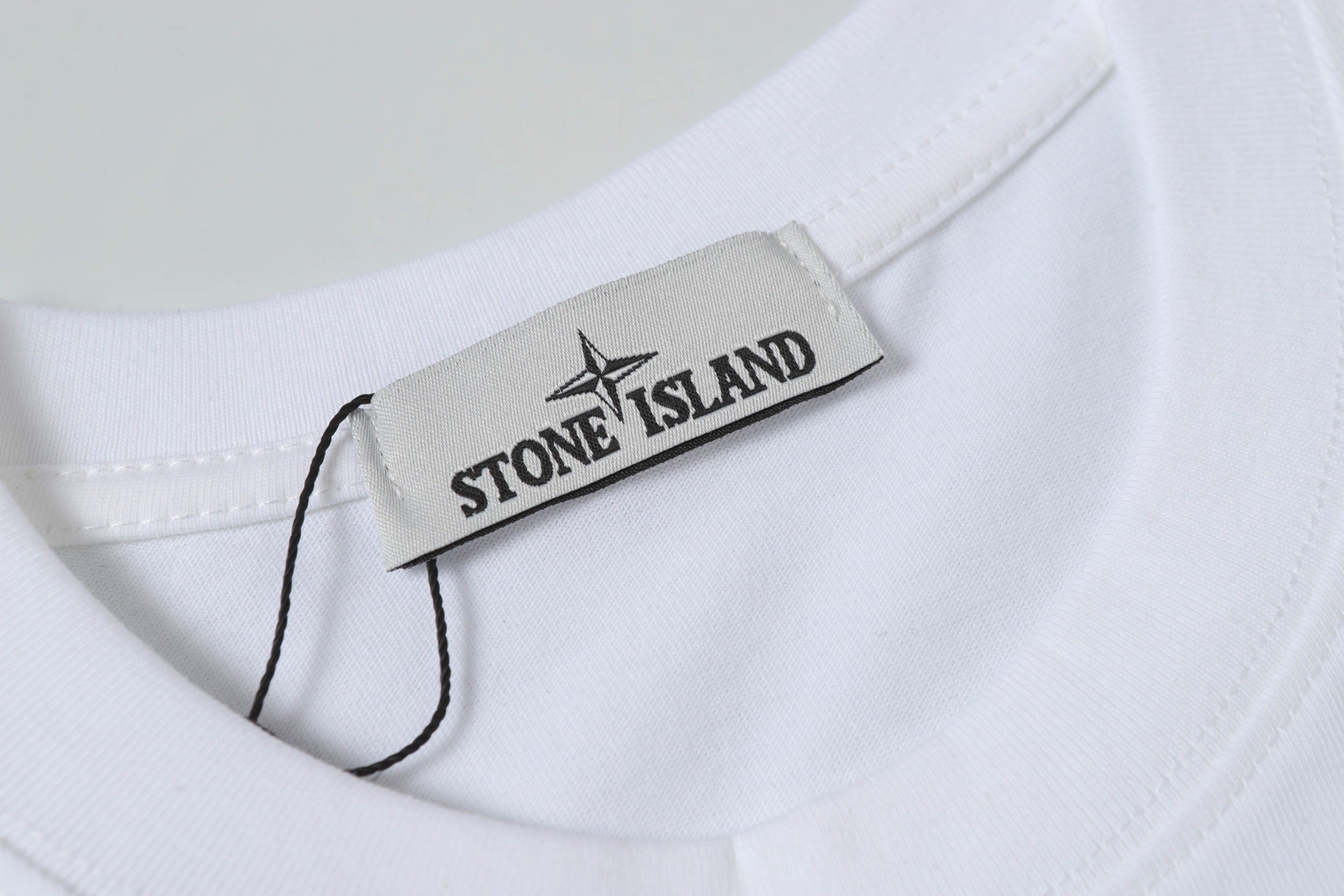 White Stone Island T-shirt with brand neck label inside collar.