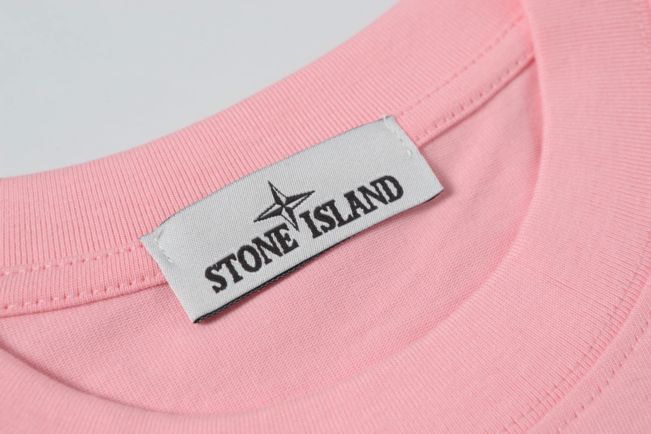 Pink crew-neck T-shirt with white Stone Island logo label