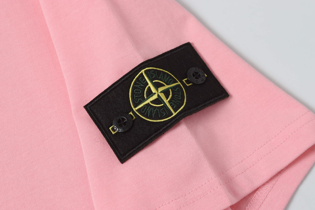 Pink T-shirt with black sleeve patch featuring yellow Stone Island emblem