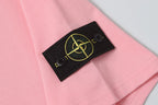 Pink T-shirt with black sleeve patch featuring yellow Stone Island emblem