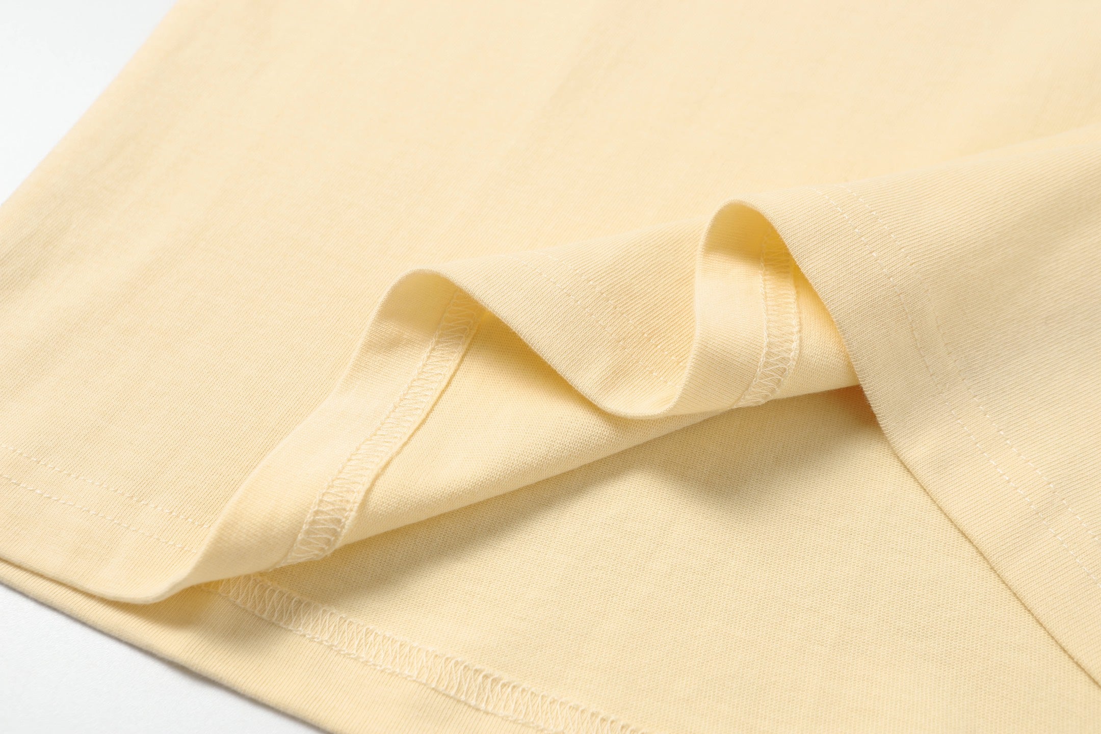 Cream T-shirt hem and sleeve cuff stitching detail