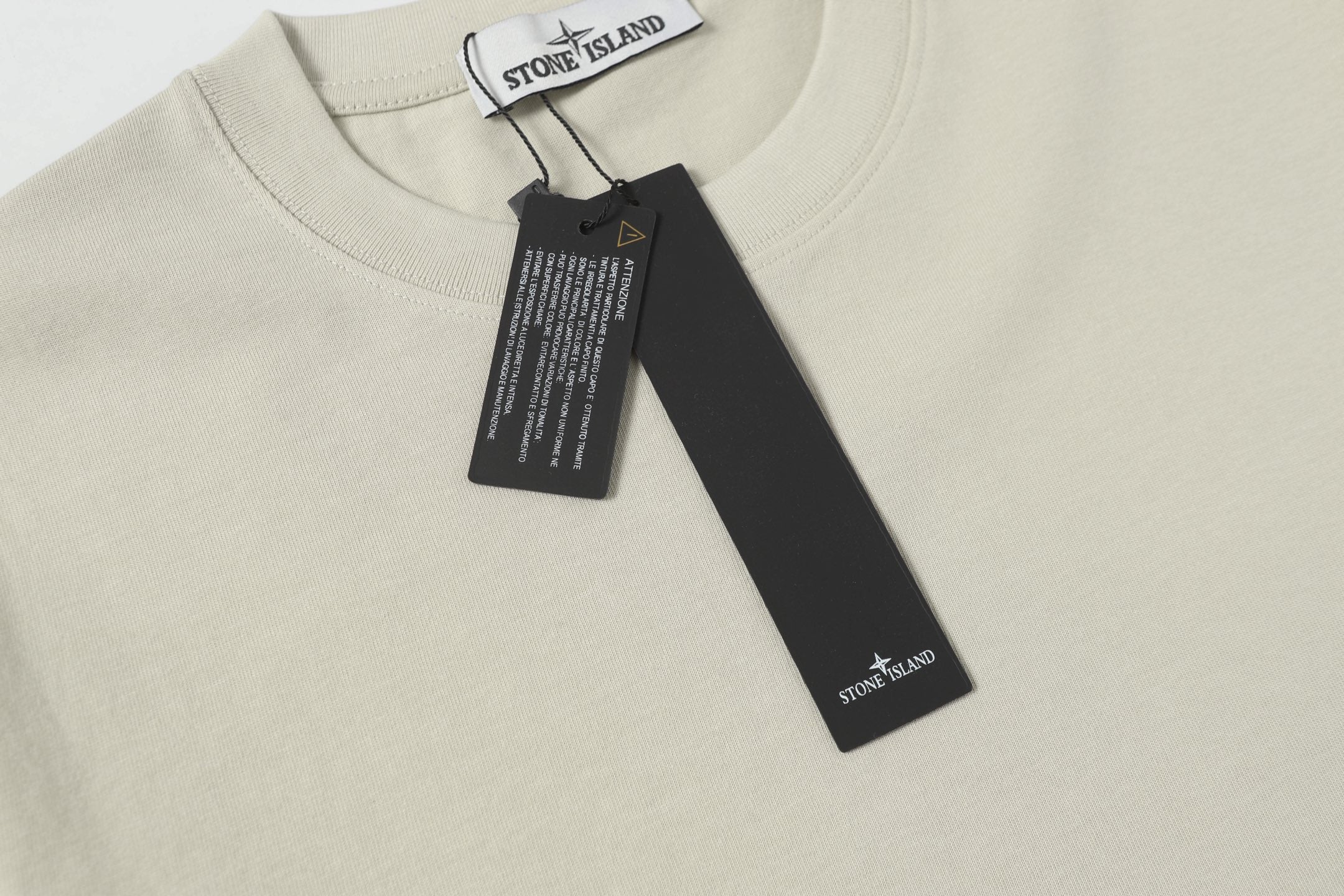 Light beige crew-neck T-shirt neckline with hanging brand tag