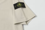 Light beige T-shirt sleeve with black patch and yellow logo