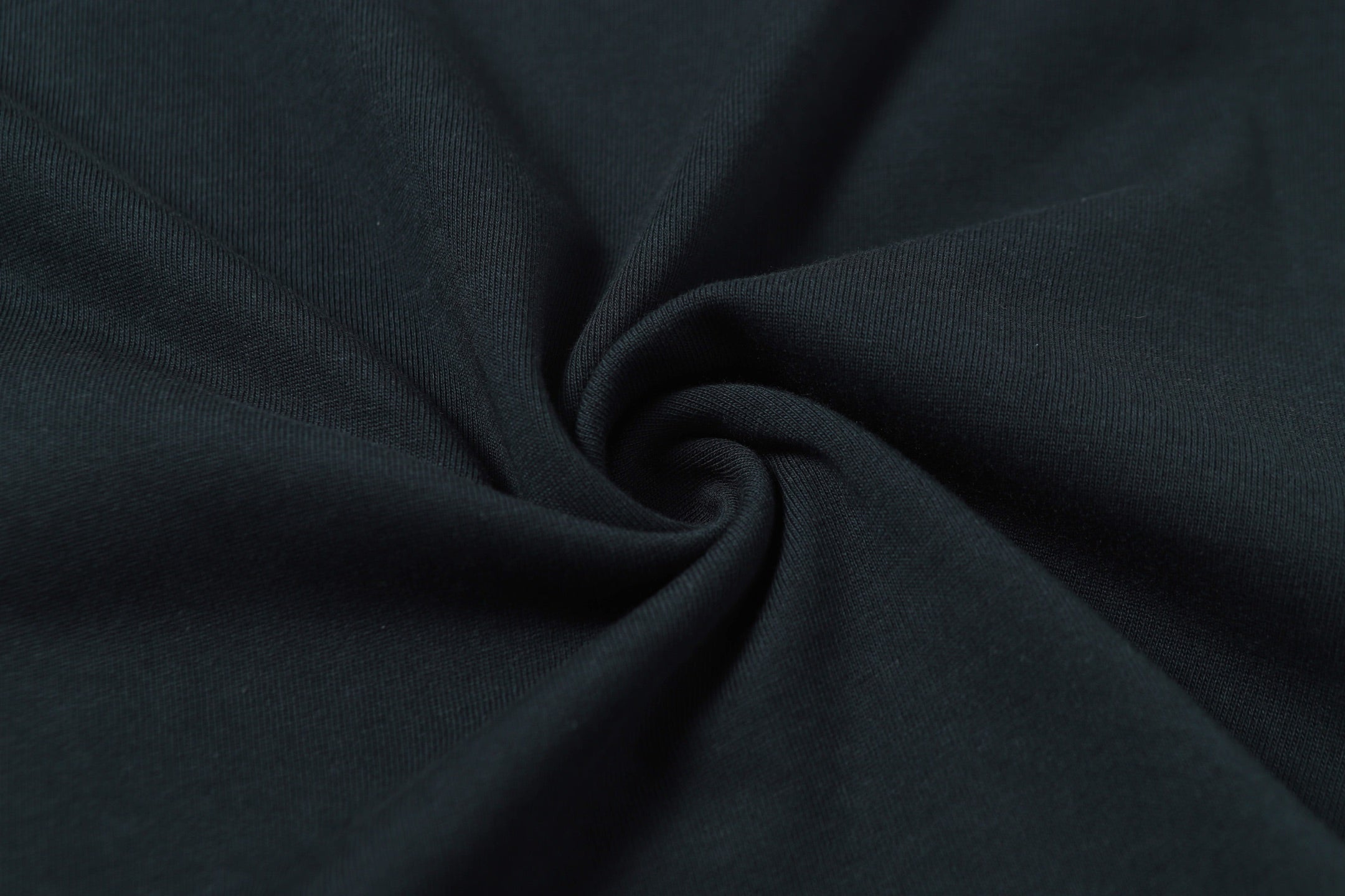 Stone Island T-shirt fabric close-up showing knit texture in dark color