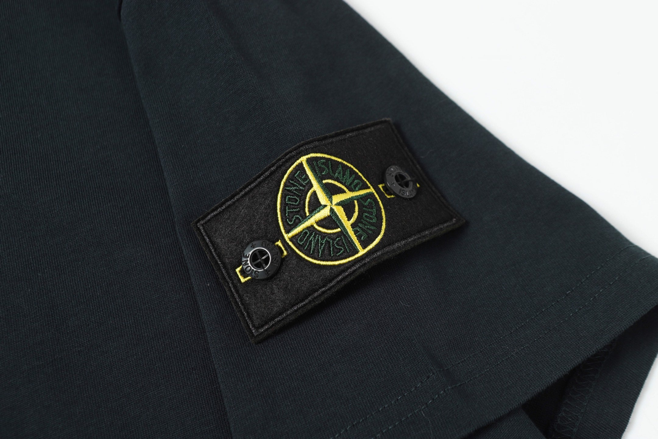 Stone Island T-shirt featuring a yellow outlined logo patch on chest