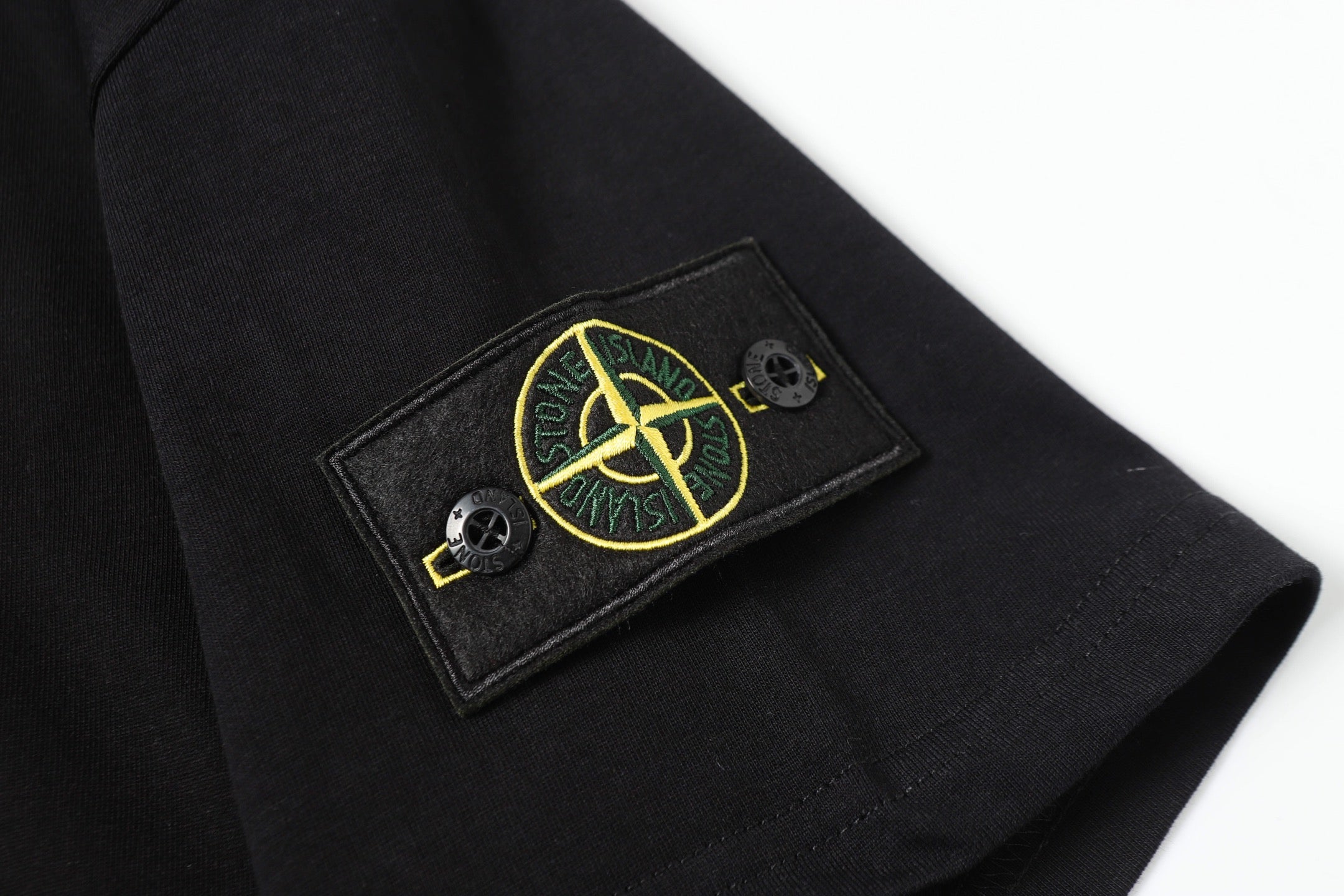 Black short-sleeve T-shirt with embroidered Stone Island patch on cuff