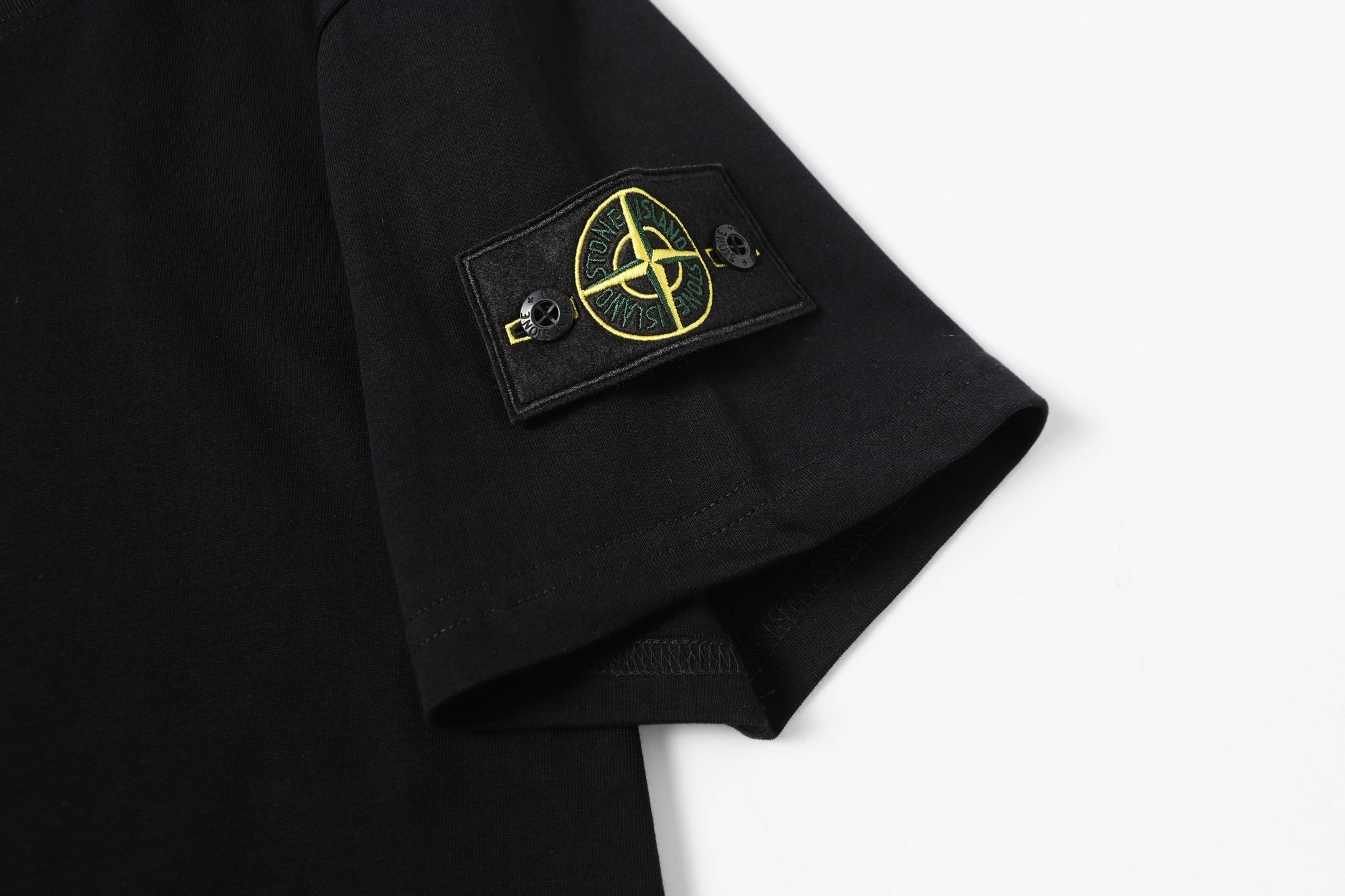 Black T-shirt sleeve patch with yellow emblem detail