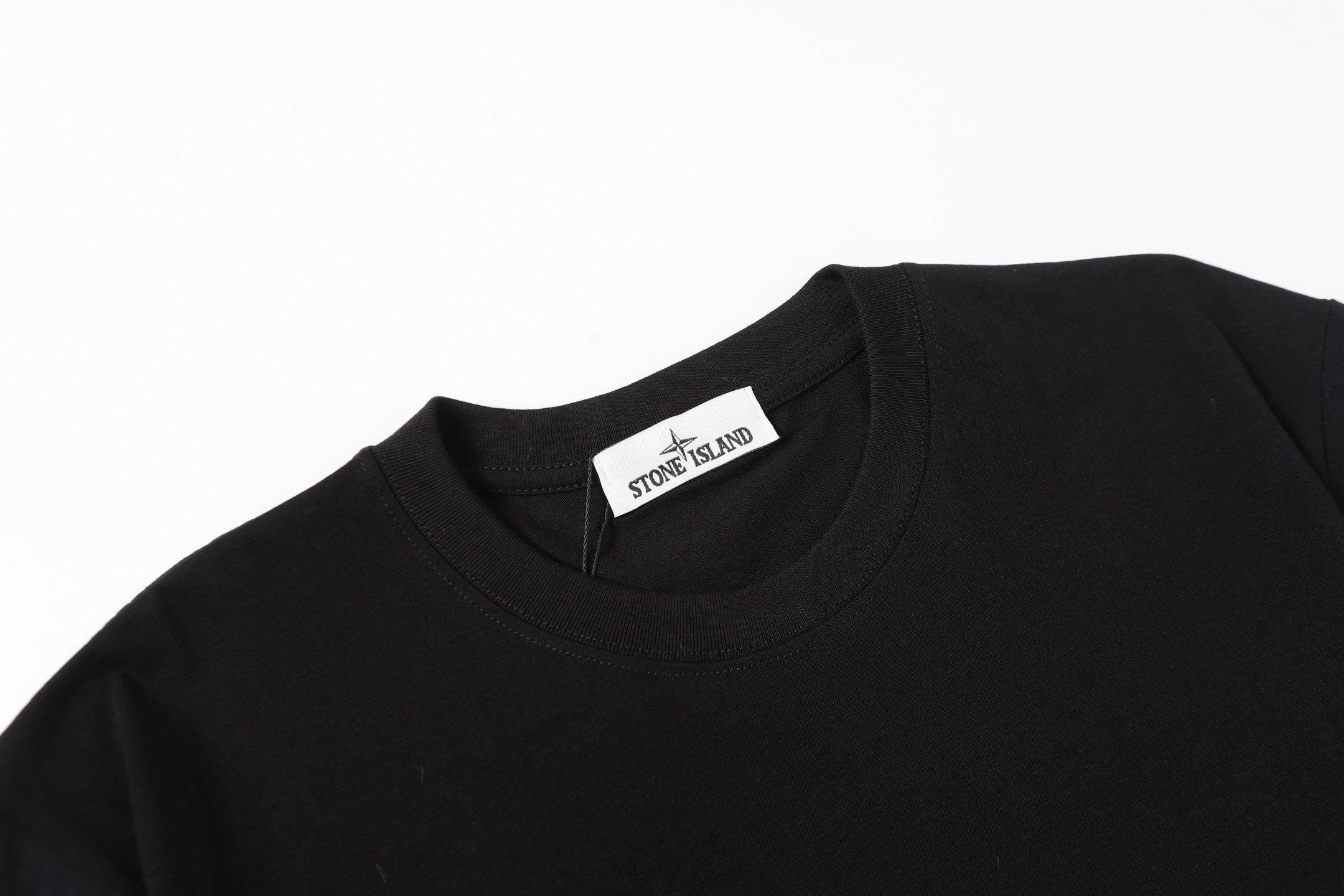 Black crew-neck T-shirt collar with Stone Island tag