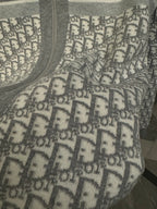 Close-up of Dior monogram pattern panel on gray hoodie