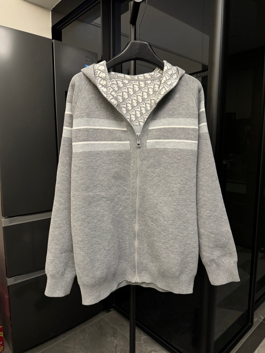 Gray zip-up hoodie with hood, off-white stripe bands, and center zipper