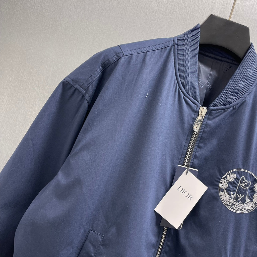 Navy bomber jacket with ribbed collar, zip front, Dior logo patch on chest.