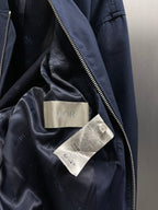 Navy bomber jacket interior lining with Dior tag labels and inner pocket seam.