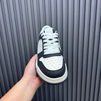 Amiri low-top sneakers, front view with black side panels and white toe