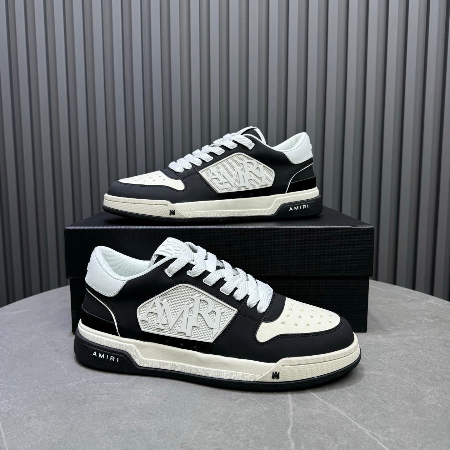 Amiri lace-up sneakers on box, black-and-white side profile with logo plate
