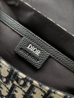 Inside view of Dior bag with black leather label and monogram canvas pocket edge