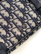 Close-up of Dior monogram canvas with textured fabric and small Dior logo plaque
