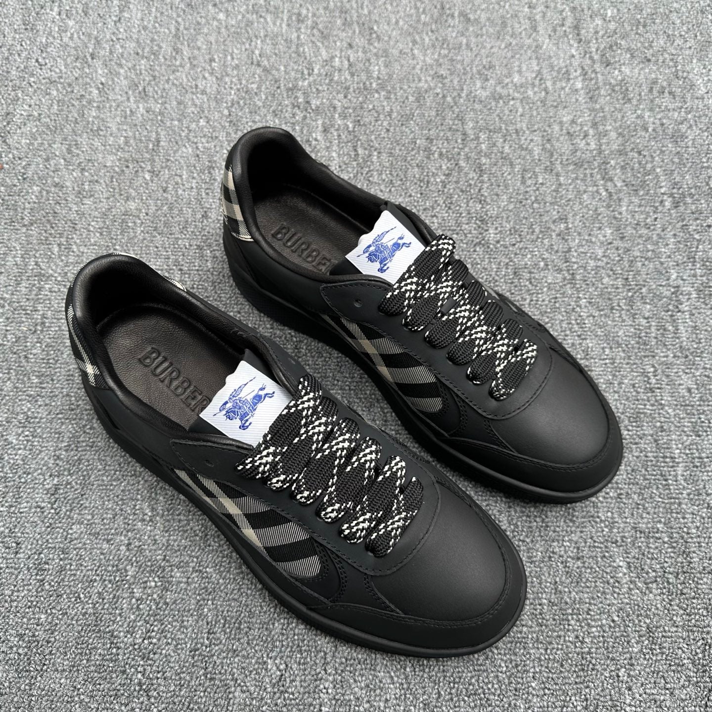 Black lace-up sneakers with check-pattern side panels and logo tags