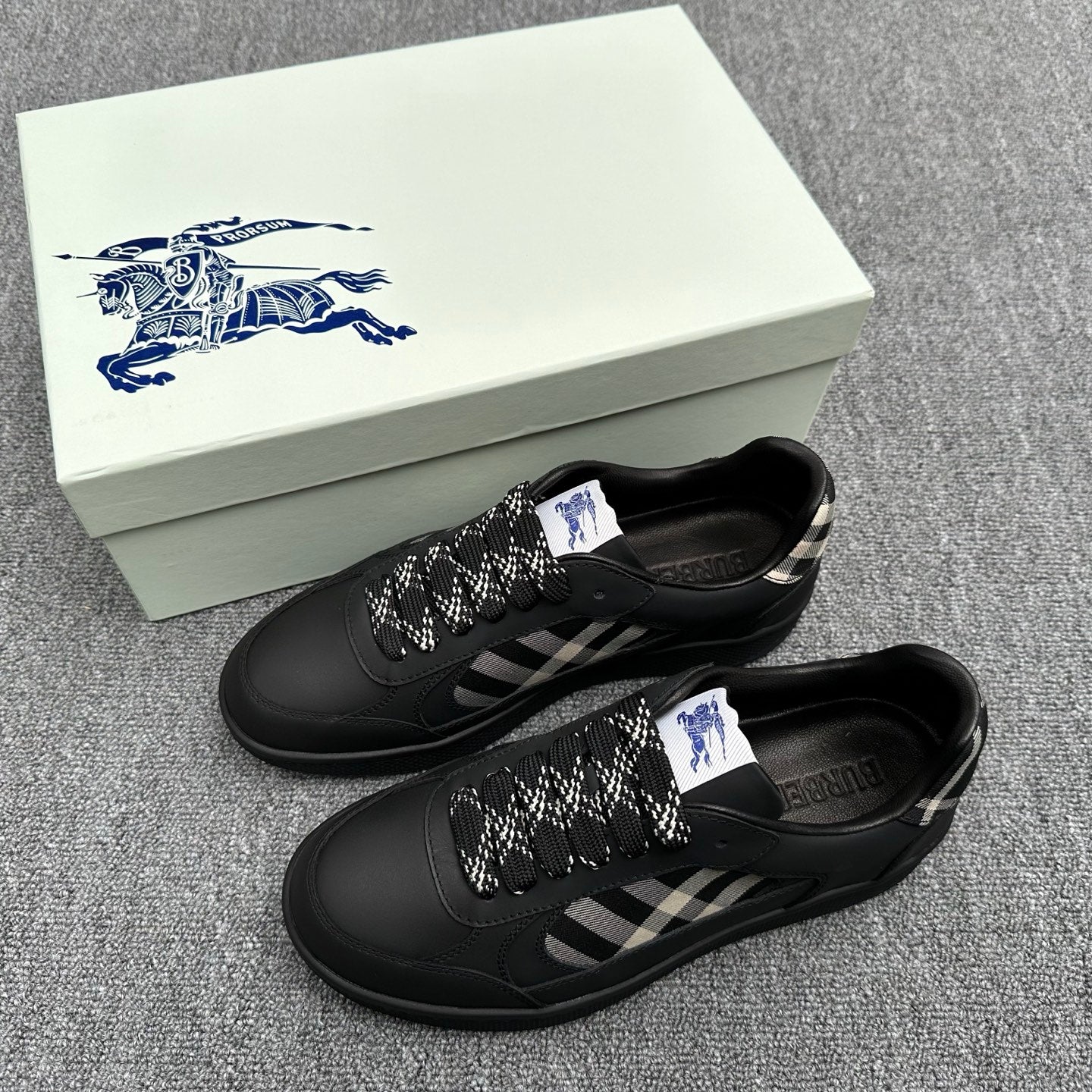 Black sneakers with check-pattern side panels and braided laces