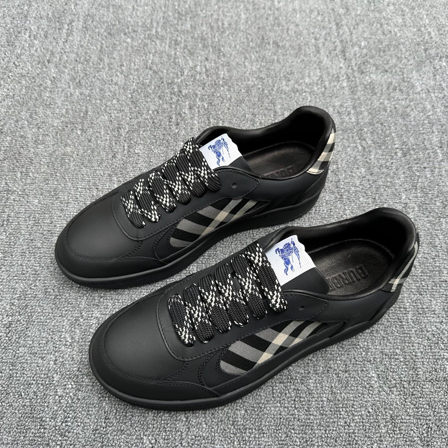 Black sneakers pair with check-pattern side panels and lace-up closure