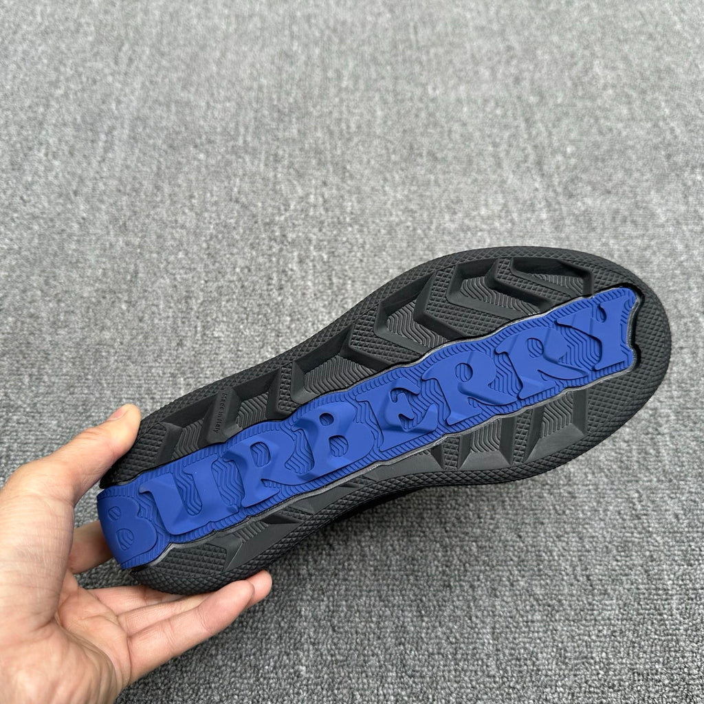 Black outsole with blue tread strip and textured traction pattern