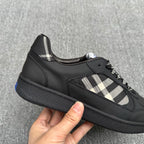 Black low-top sneakers with check-pattern side detail and lace-up design