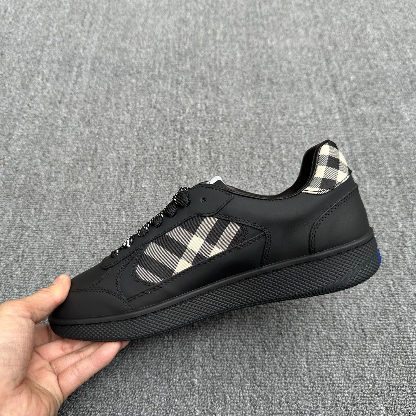 Black sneakers with check-pattern side panel and lace-up closure