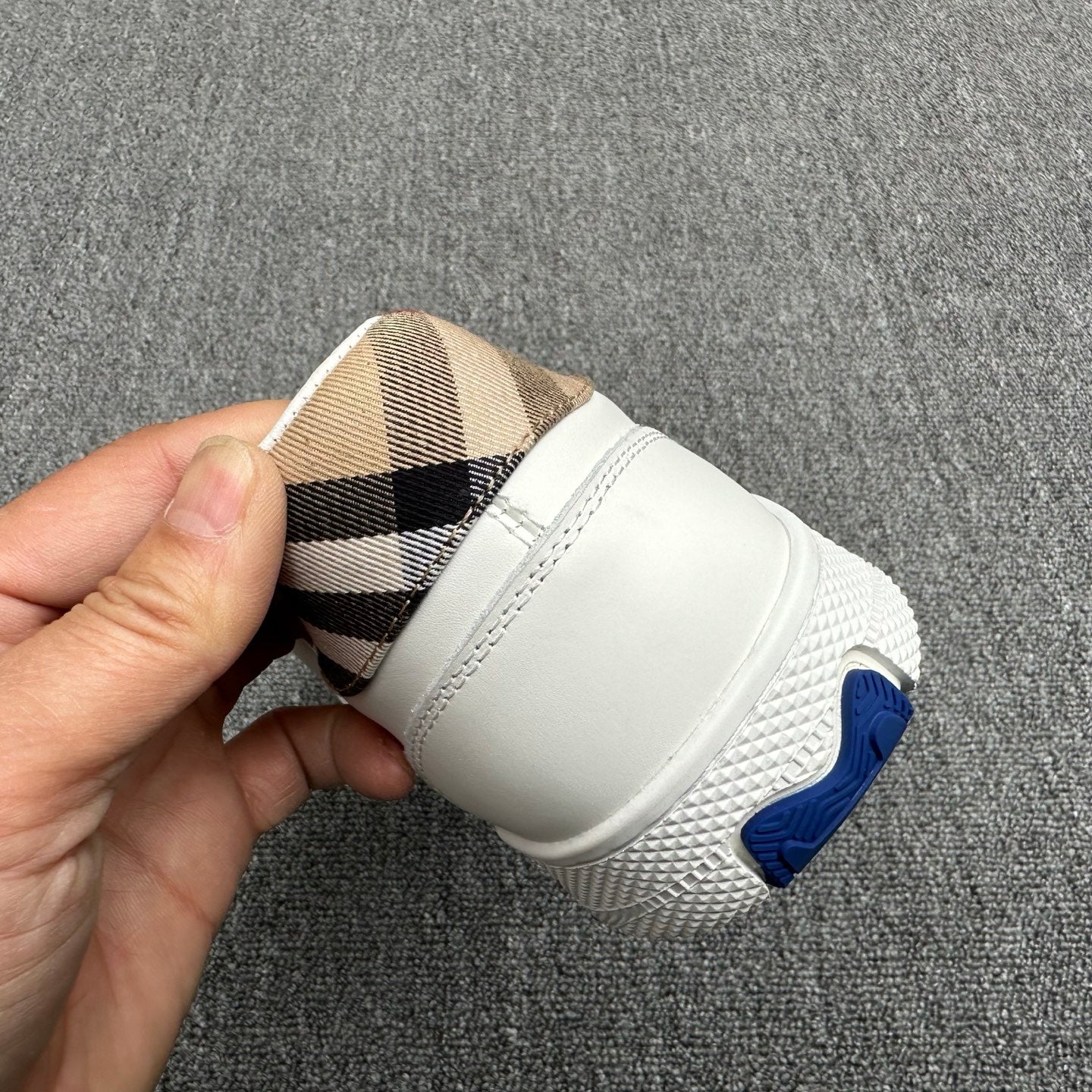 White sneaker heel with plaid lining detail and blue logo accent