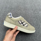 Burberry low-top sneaker held by hand, beige leather with check inlay and blue lining