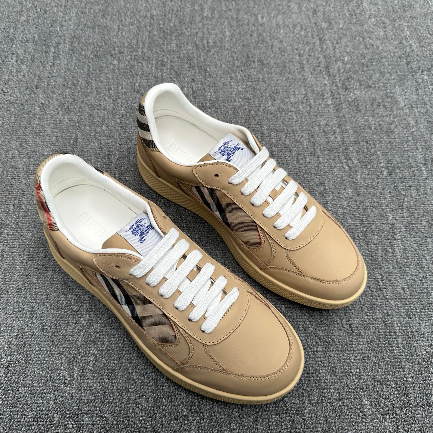 Burberry beige sneakers with white laces and check stripe, toe view of pair