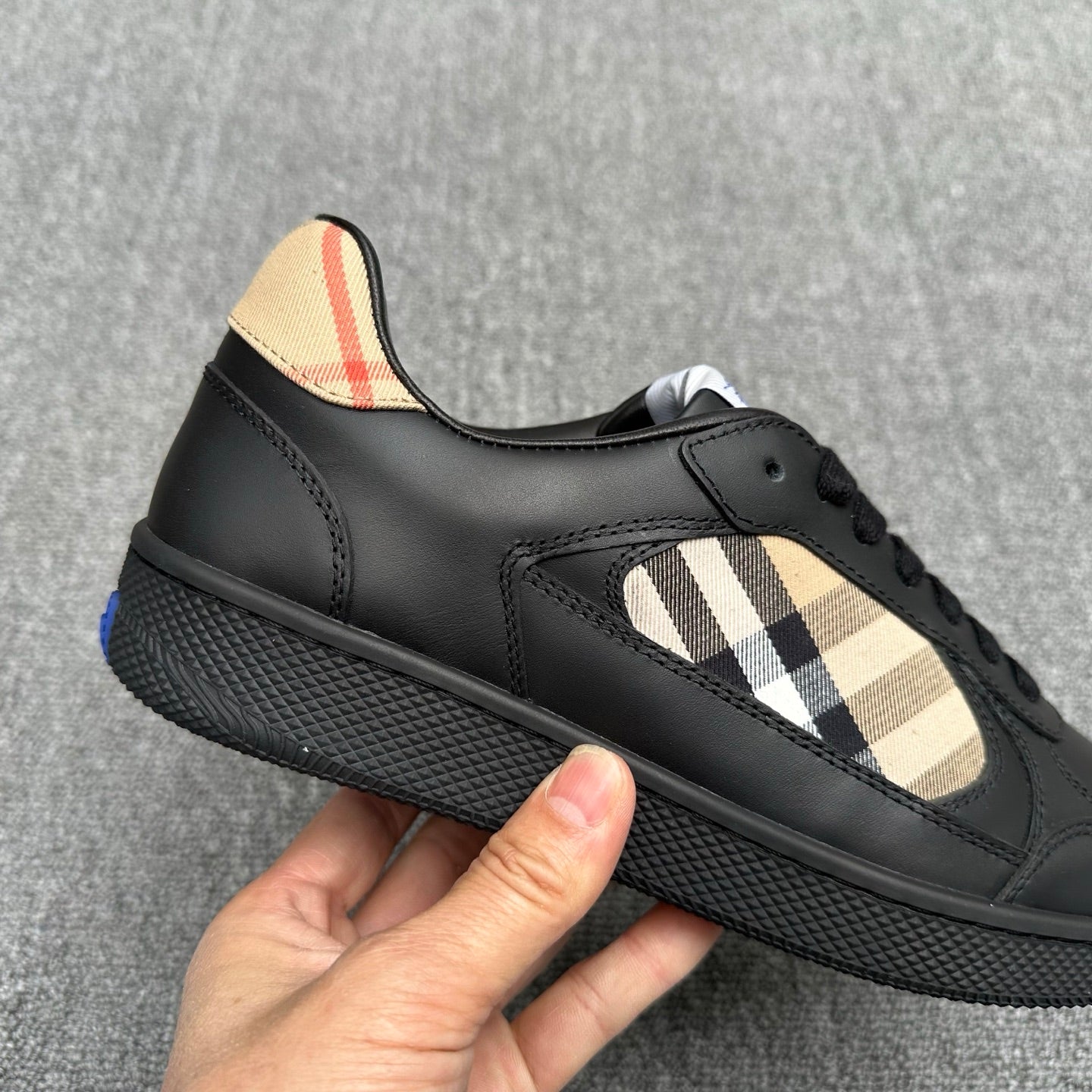 Black low-top sneaker with beige check overlay and lace-up vamp