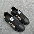 Black leather sneakers with lace-up front and beige plaid inlay on sides