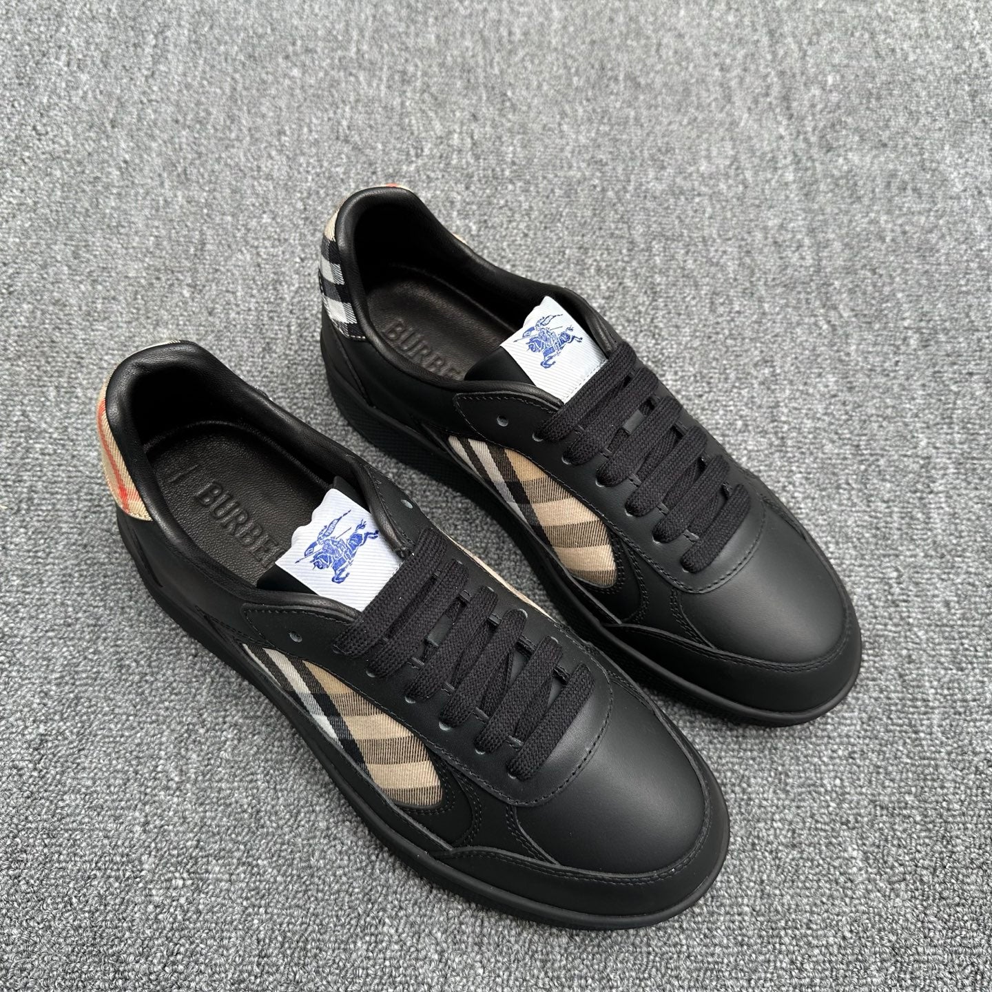 Black leather sneakers with lace-up front and beige plaid inlay on sides