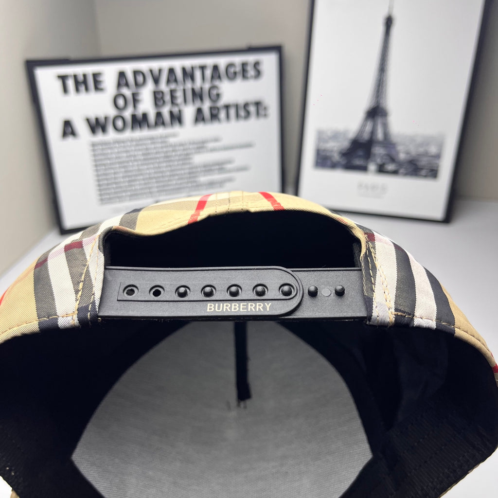 Burberry baseball cap with black brim, beige plaid crown, and Burberry logo on metal strap