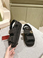 Black Gucci sandals with adjustable buckle strap and tread sole, side view