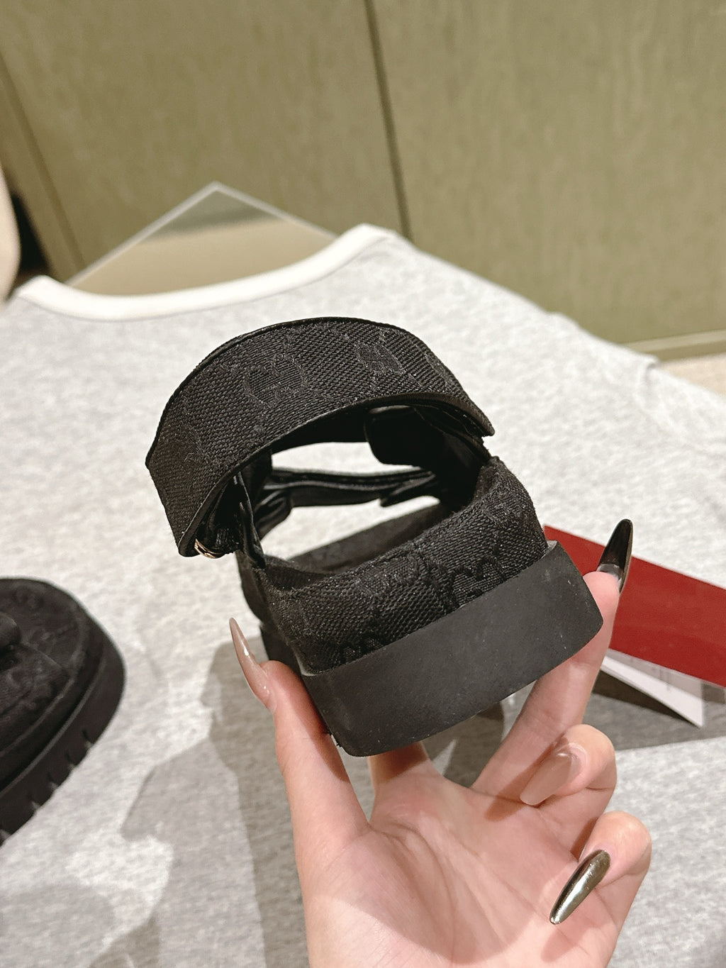 Black Gucci sandals heel view, textured footbed and open back adjustable strap