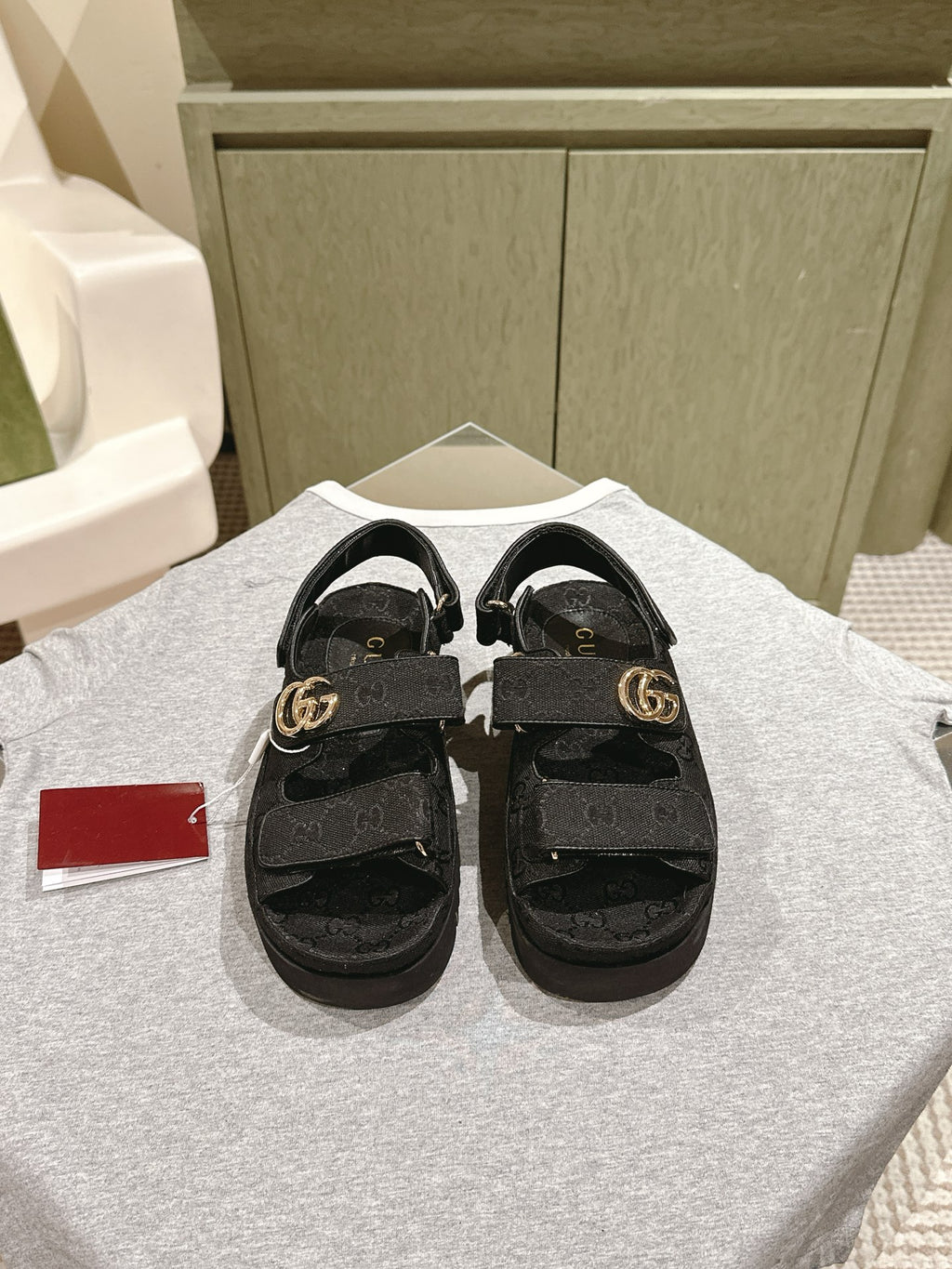 Black Gucci slide sandals with adjustable strap and gold-tone GG buckle