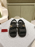 Black Gucci slide sandals with adjustable strap and gold-tone GG buckle