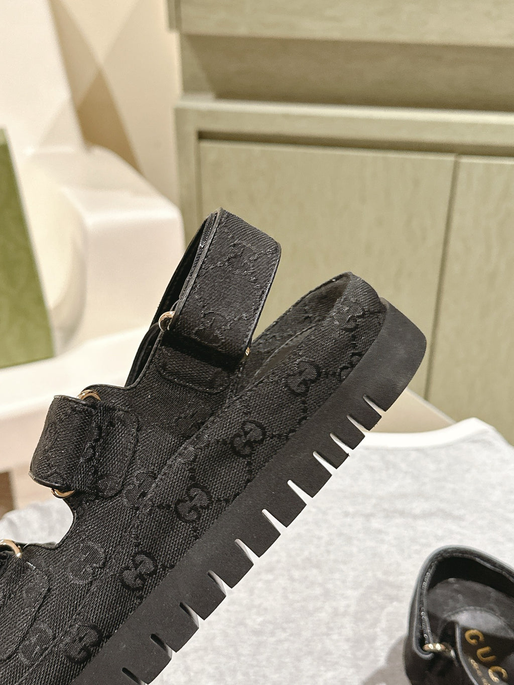 Black Gucci sandals close-up: embossed upper, adjustable strap, chunky rubber sole