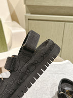 Black Gucci sandals close-up: embossed upper, adjustable strap, chunky rubber sole