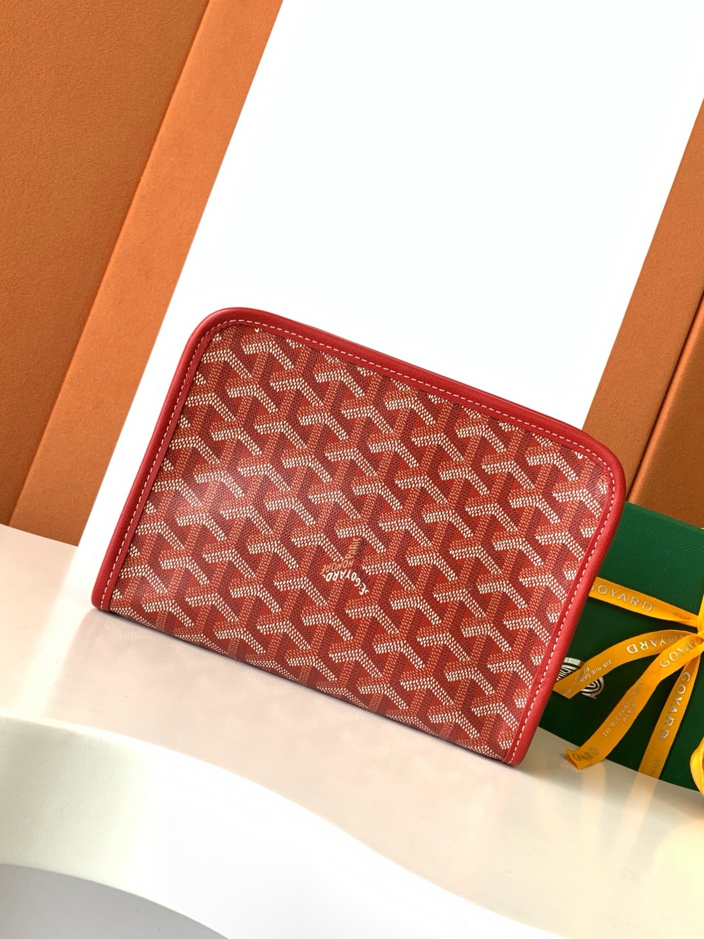 Red Goyard-pattern zip wallet with rounded corners and leather edge trim