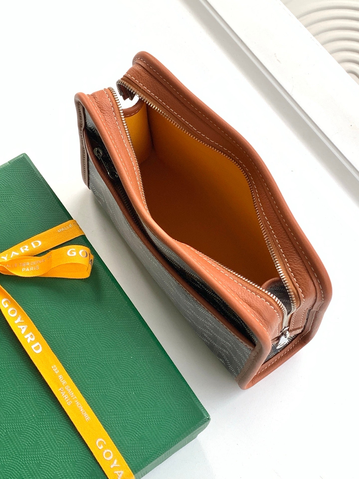 Goyard zip pouch open, showing tan lining and brown leather interior