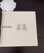 Silver-tone rhinestone Chanel stud earrings with dangling charms