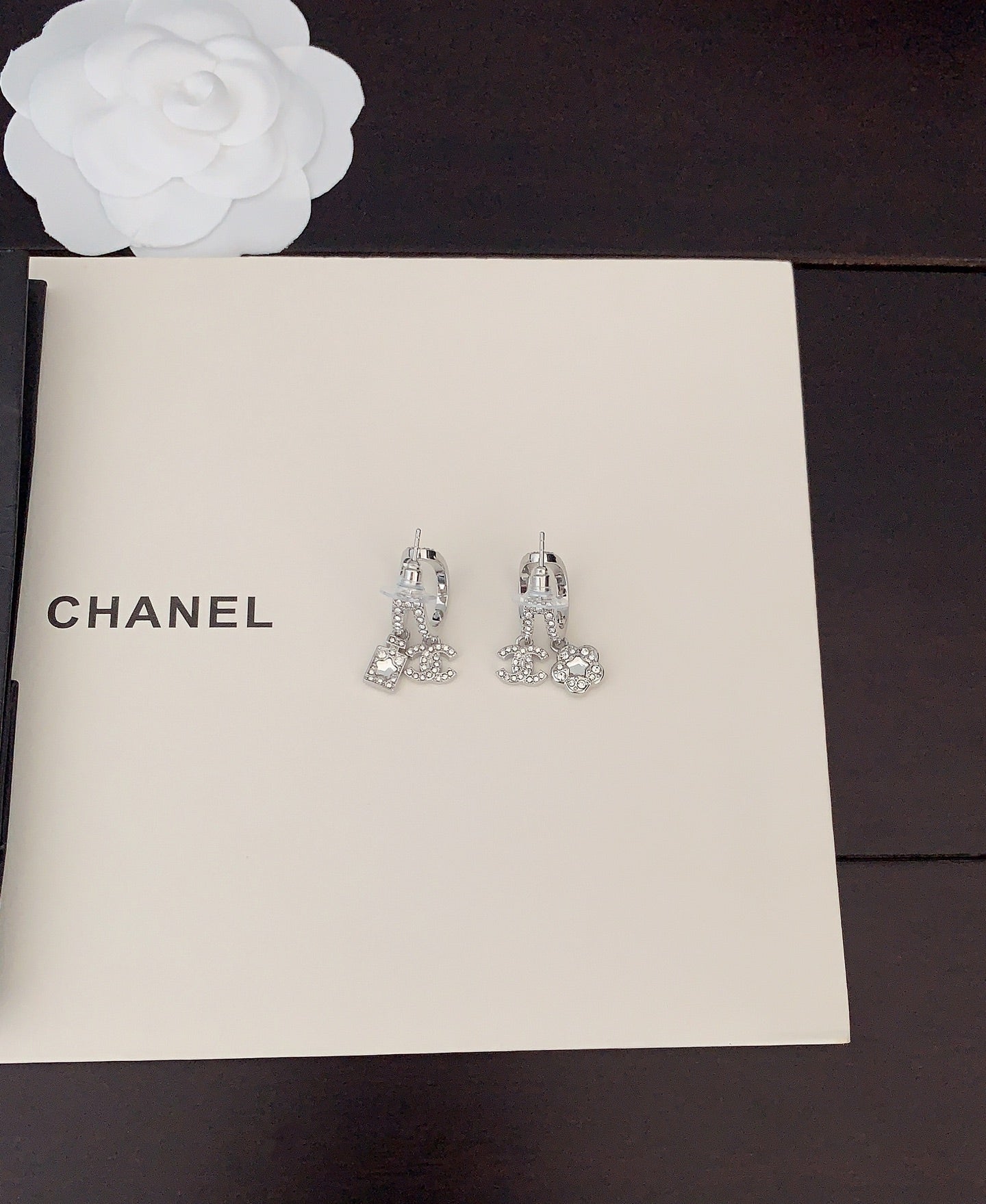 Silver-tone rhinestone Chanel stud earrings with dangling charms