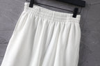 White shorts with elastic waistband and gathered pleats at top
