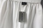 White shorts with Balenciaga tag hanging from the waistband.