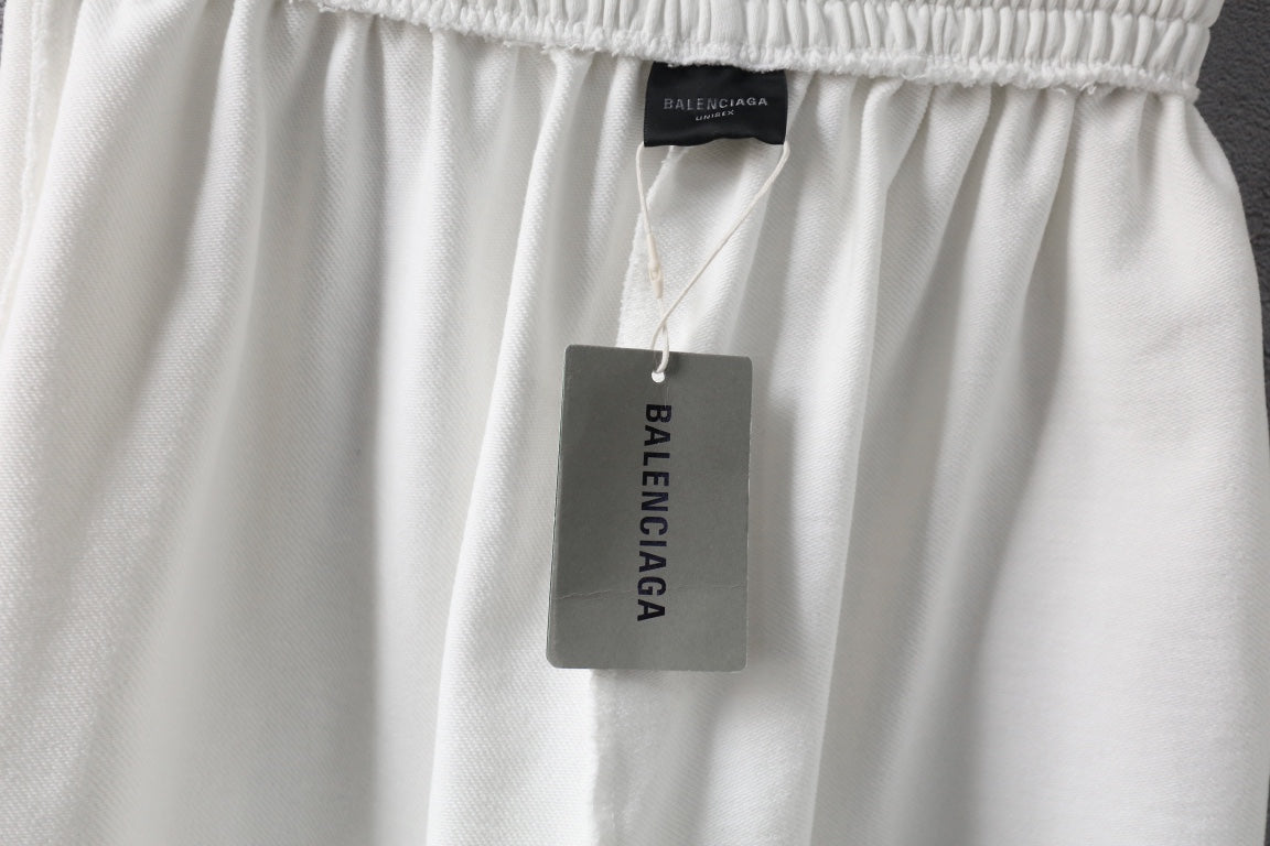 White shorts with Balenciaga tag hanging from the waistband.