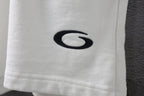 White shorts leg with black oval logo embroidery.