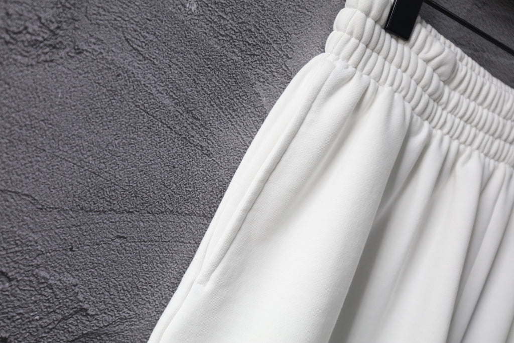 White shorts with ribbed elastic waistband and stitched pleats